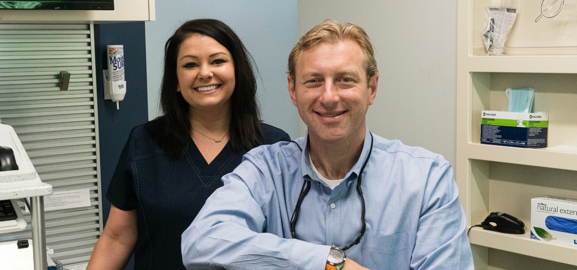 Dr. Bill and staff member smiling in a patient room at Durham DDS.