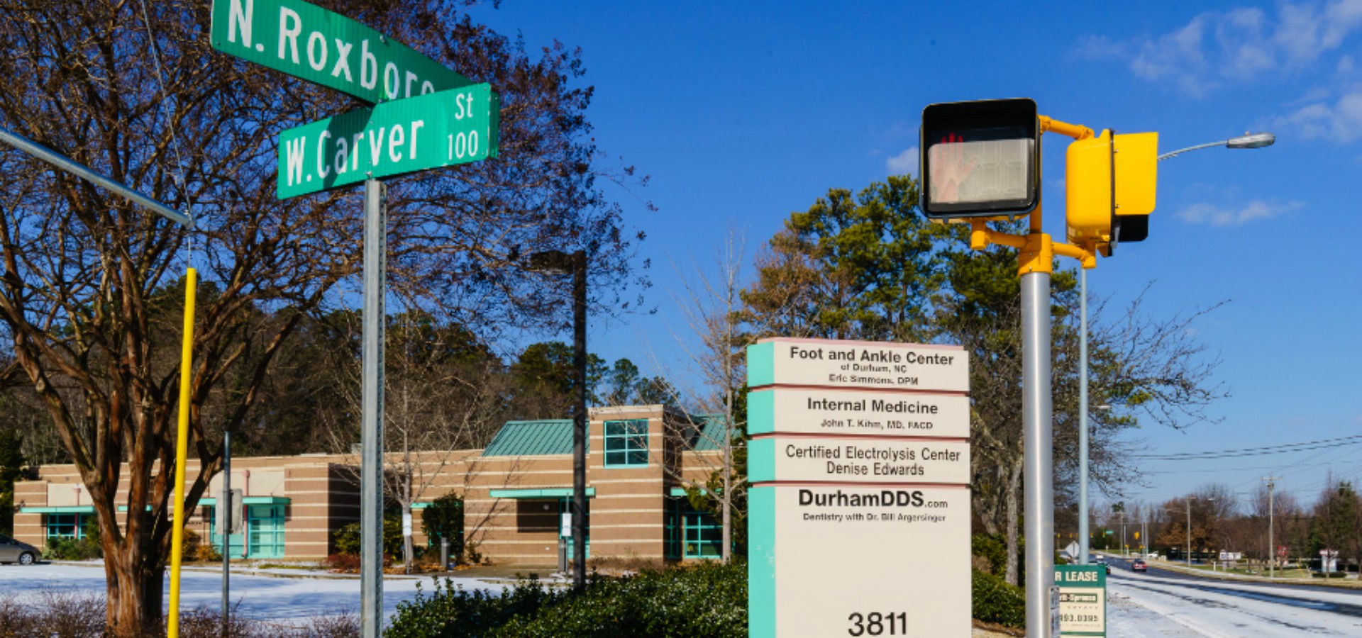 Exterior shot of Durham DDS including a view of the building and street signs.